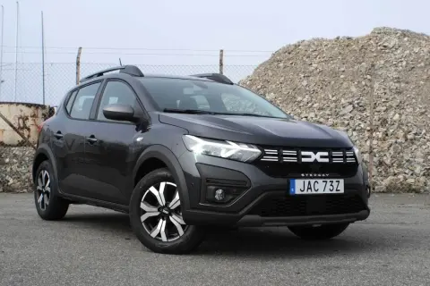 En mörkgrå Dacia Sandero Stepway står parkerad utomhus. Bilen är redo för ett däcktest.