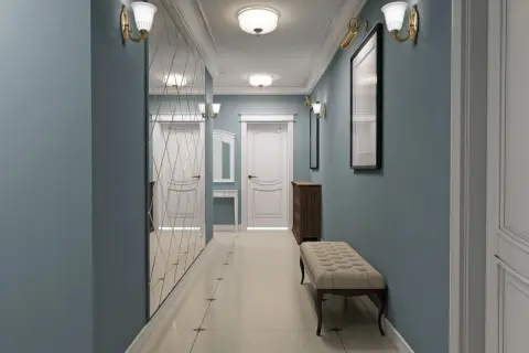 Długi wąski przedpokój inspiracje: lustrzana ściana, ławka, komoda i eleganckie oświetlenie tworzą przytulną przestrzeń.