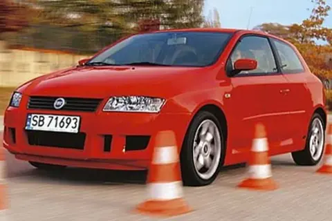 Czerwony Fiat Stilo 1.9 JTD manewruje między pachołkami na torze.