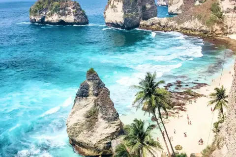 Rajska plaża z palmami i turkusową wodą. Marzysz o podróży? Sprawdź, ile trwa lot na Bali!