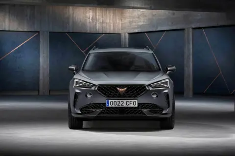 Szary SUV z charakterystycznym logo na grillu. To Cupra, jaka to marka? Sportowy design i nowoczesne linie.