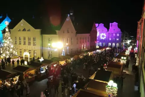 Tłoczny jarmark bożonarodzeniowy Olsztyn nocą. Rozświetlona choinka, stragany i kolorowe iluminacje budzą świąteczny nastrój.