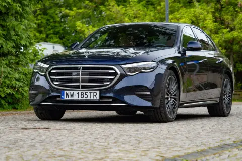 Ciemnoniebieski Mercedes E Klasa na mokrej nawierzchni. Szczegółowe dane techniczne tego modelu są imponujące.