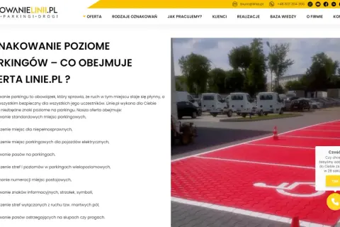 Malowanie oznaczenie miejsca dla niepełnosprawnych na czerwonym tle parkingu. W tle białe busy i drzewa.