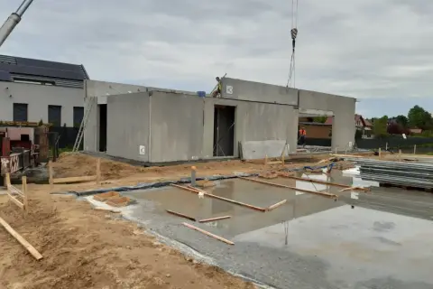 Budowa domu z wielkiej płyty w toku. Betonowe ściany i strop czekają na dalsze prace.