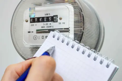 Zapisywanie odczytu licznika energii elektrycznej, by dowiedzieć się, jak obliczyć zużycie prądu.