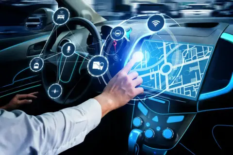 Ręka Adama dotyka ekranu nawigacji w samochodzie przyszłości. Ikony symbolizują funkcje smart car.