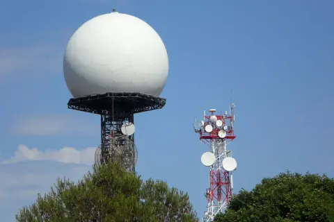 Duża biała kopuła, prawdopodobnie najlepszy radar pogodowy, góruje nad wieżą telekomunikacyjną.