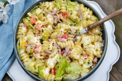 En stor skål med krämig pastasallad med skinka, paprika och sallad. Perfekt dressing till pastasallad för en sommarlunch.