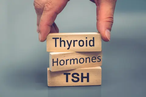 Dłonie układają kostki z napisami "Thyroid", "Hormones", "TSH". Dowiedz się, jaki poziom TSH jest niebezpieczny.