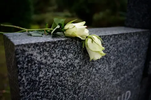 Białe róże na granitowym nagrobku. Czekamy, od kiedy wzrośnie zasiłek pogrzebowy, by godnie pożegnać bliskich.