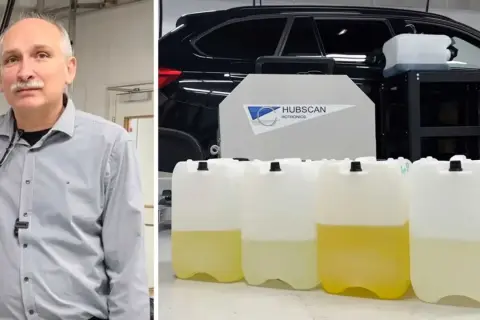 Man med mustasch bredvid en personbil med flera dunkar med vätska, troligen för blankdiesel.