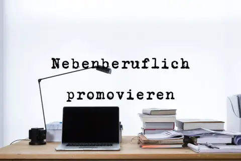 Schreibtisch mit Laptop, Büchern und Lampe. Der Text "Nebenfachlich promovieren" regt zum Nachdenken über die Promotion neben dem Beruf an.