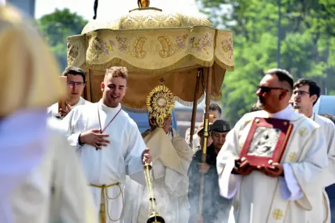 Procesja Bożego Ciała 9 czerwca. Wierni niosą monstrancję pod baldachimem, towarzyszą im księża w białych szatach i kadzidło.