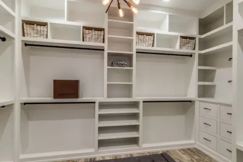 Armario de pladur blanco con cestas, cajas y barras para colgar.