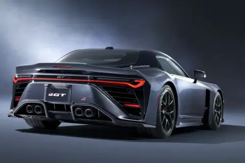Tylna część sportowego, ciemnoszarego coupe Toyota GR GT z czterema końcówkami wydechu i ostrymi światłami LED.