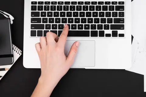 Dłoń naciska klawisz "C" na klawiaturze laptopa, pokazując, jak włączyć klawiaturę.