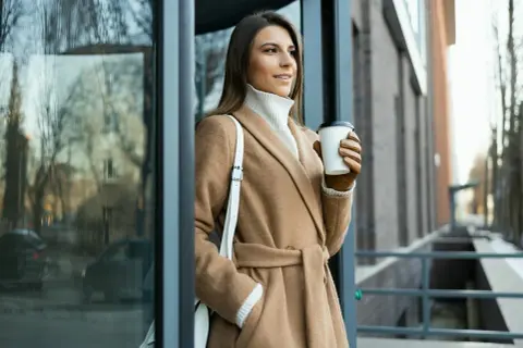 Elegancka stylizacja na Wszystkich Świętych: beżowy płaszcz, golf i skórzane rękawiczki. Idealny strój na chłodne dni.