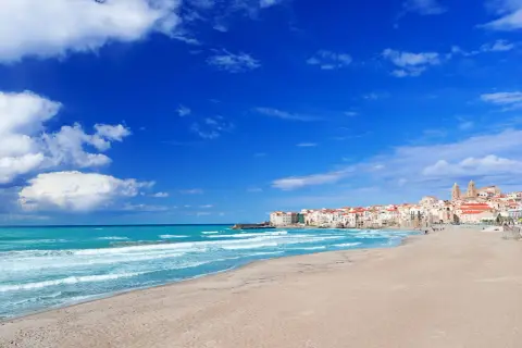 Le spiagge di Cefalù, con la loro sabbia dorata e il mare azzurro, invitano a rilassarsi sotto il sole siciliano.