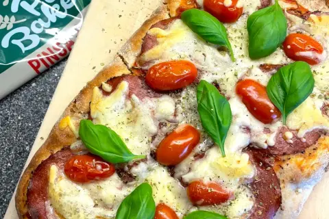 En nybakad pizza med tomater, basilika och ost. Perfekt för en mysig kväll, detta är nog den godaste pizzan!