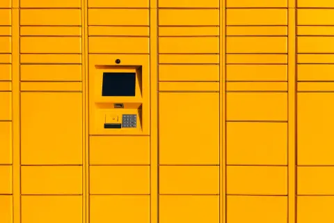 Żółty paczkomat InPost z ekranem dotykowym i klawiaturą numeryczną.