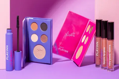 Fioletowa maskara i paletki cieni do powiek z kolekcji Inglot PLAYINN. Obok błyszczyki i pomadki w odcieniach nude.