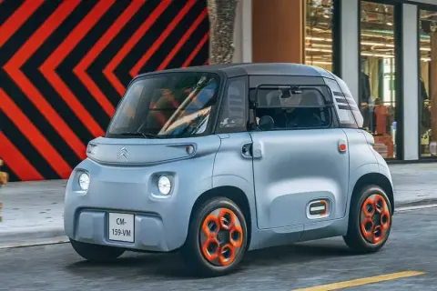 Citroën Ami, un quadriciclo elettrico compatto, sfreccia in città. La sua lunghezza ridotta la rende perfetta per muoversi agilmente nel traffico urbano.