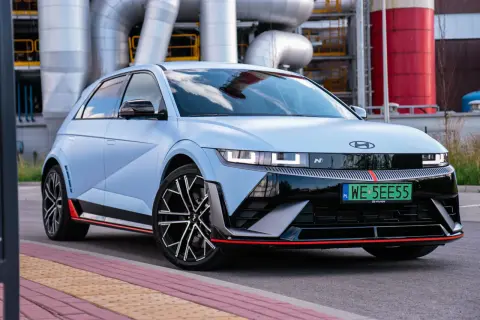 Niebieski Hyundai Ioniq 5 N z czerwonymi akcentami na tle przemysłowej infrastruktury.