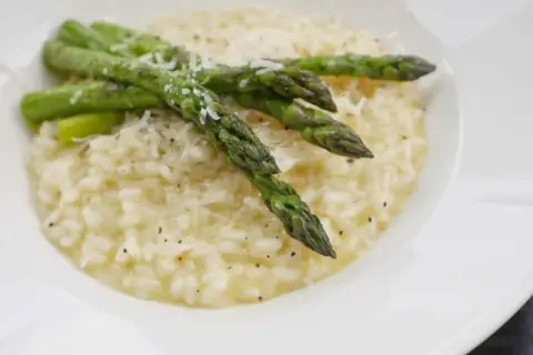 Krämig sparris risotto med toppad med färsk sparris och riven parmesan. En härlig rätt som passar perfekt till våren.