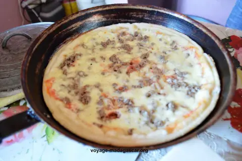 Pizza à la poêle, garnie de viande hachée et de fromage fondant, prête à être dégustée.