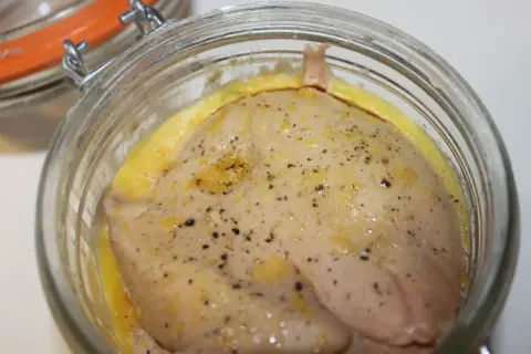 Foie gras cru assaisonné, prêt pour la recette du parfait. Un délice en préparation dans un bocal en verre.