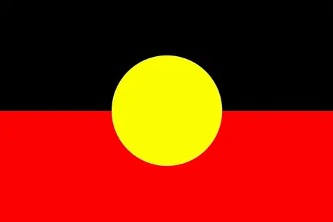 Flaga Australii Aborygenów: czarny pas u góry, czerwony na dole, a pośrodku żółte koło symbolizujące słońce.