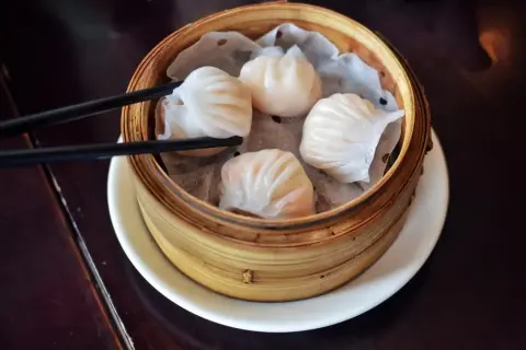 Pyszne dim sum w bambusowym parowniku, gotowe do chwycenia pałeczkami.