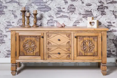 Buffet en bois sculpté, prêt à recevoir une nouvelle teinte. Ses portes ornées de motifs étoilés et ses tiroirs invitent à le teindre un meuble en bois déjà teint pour un relooking.