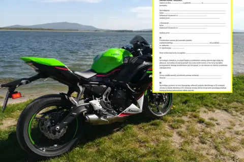 Zielony motocykl Kawasaki stoi nad jeziorem obok umowy kupna-sprzedaży.