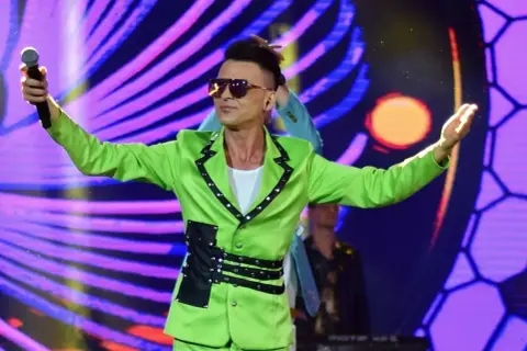 Artysta w jaskrawozielonej marynarce z czarnymi pasami i ćwiekami śpiewa na scenie. Serce to nie sługa, czuć to w jego energii.