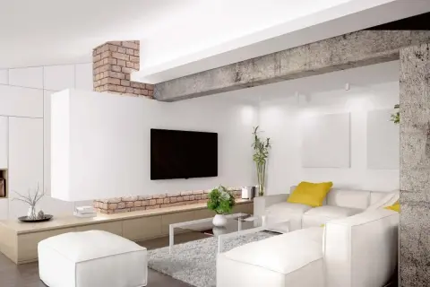 Nowoczesny salon z białymi sofami i pufami. Ceglany podciąg zamiast ściany nośnej dodaje industrialnego charakteru.