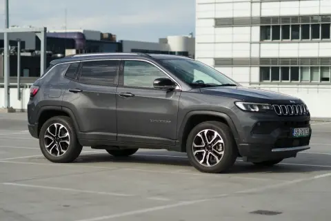 Szary Jeep Compass na parkingu. Zastanawiasz się nad jego spalaniem? Ten model oferuje dobre osiągi i komfort jazdy.