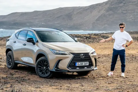 Mężczyzna prezentuje jeden z najnowszych lexus suv modele na tle surowego krajobrazu z morzem i górami.