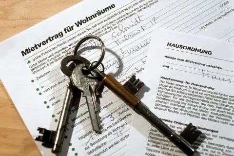 Mietvertrag für Wohnung mit Schlüsseln. Der Mietvertrag und die Hausordnung sind bereit zur Unterzeichnung.