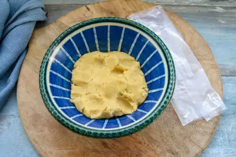 Frischer quiche teig in einer blauen Schüssel, bereit für die Zubereitung einer herzhaften Tarte.