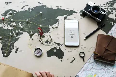 Planujesz podróż? Z mbank ubezpieczenie podróżne masz spokój ducha. Mapa świata, aparat, kompas i telefon z hasłem "Let's go travel" zachęcają do odkrywania świata.