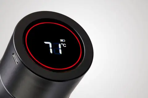 Schwarze Trinkflasche mit digitaler Anzeige (71°C) und Akku-Symbol. Eine smarte Trinkflasche mit Erinnerungsfunktion, die die Temperatur anzeigt.