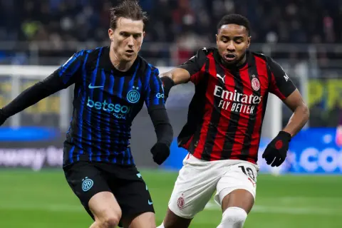 Piłkarze Interu i AC Milan, słynnego klubu piłkarskiego z Mediolanu, walczą o piłkę na boisku.