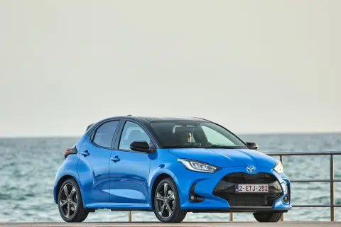 Niebieski segment a, Toyota Yaris, stoi przy morzu.