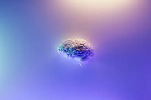 Model ludzkiego mózgu w neonowym świetle, symbolizujący ból psychogenny i złożoność ludzkiej psychiki.