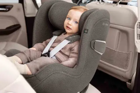 Kleines Kind im Kindersitz, das sich auf die Frage konzentriert: ab wann darf Baby in Fahrtrichtung sitzen?