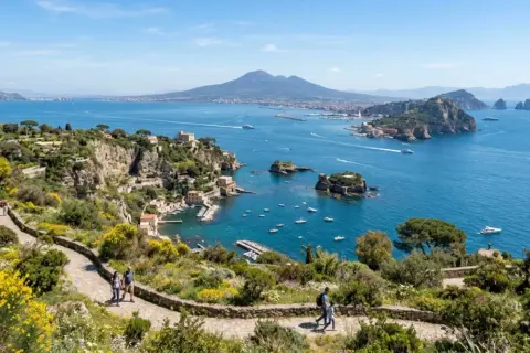 Sentiero fiorito in un giardino di agrumi con vista sul golfo e il Vesuvio.