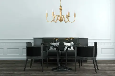 Elegancka, złota lampa zwis nad czarnym stołem z krzesłami. Idealna do wytwornej jadalni.