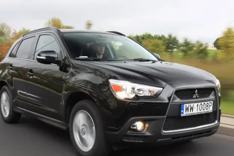 Czarny Mitsubishi ASX 1.6 benzyna w ruchu, z kierowcą za kierownicą.